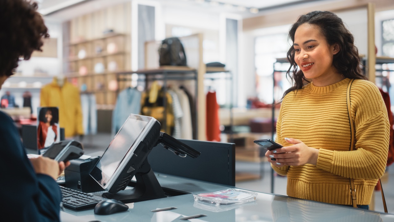 Customer holding a phone at a retail checkout